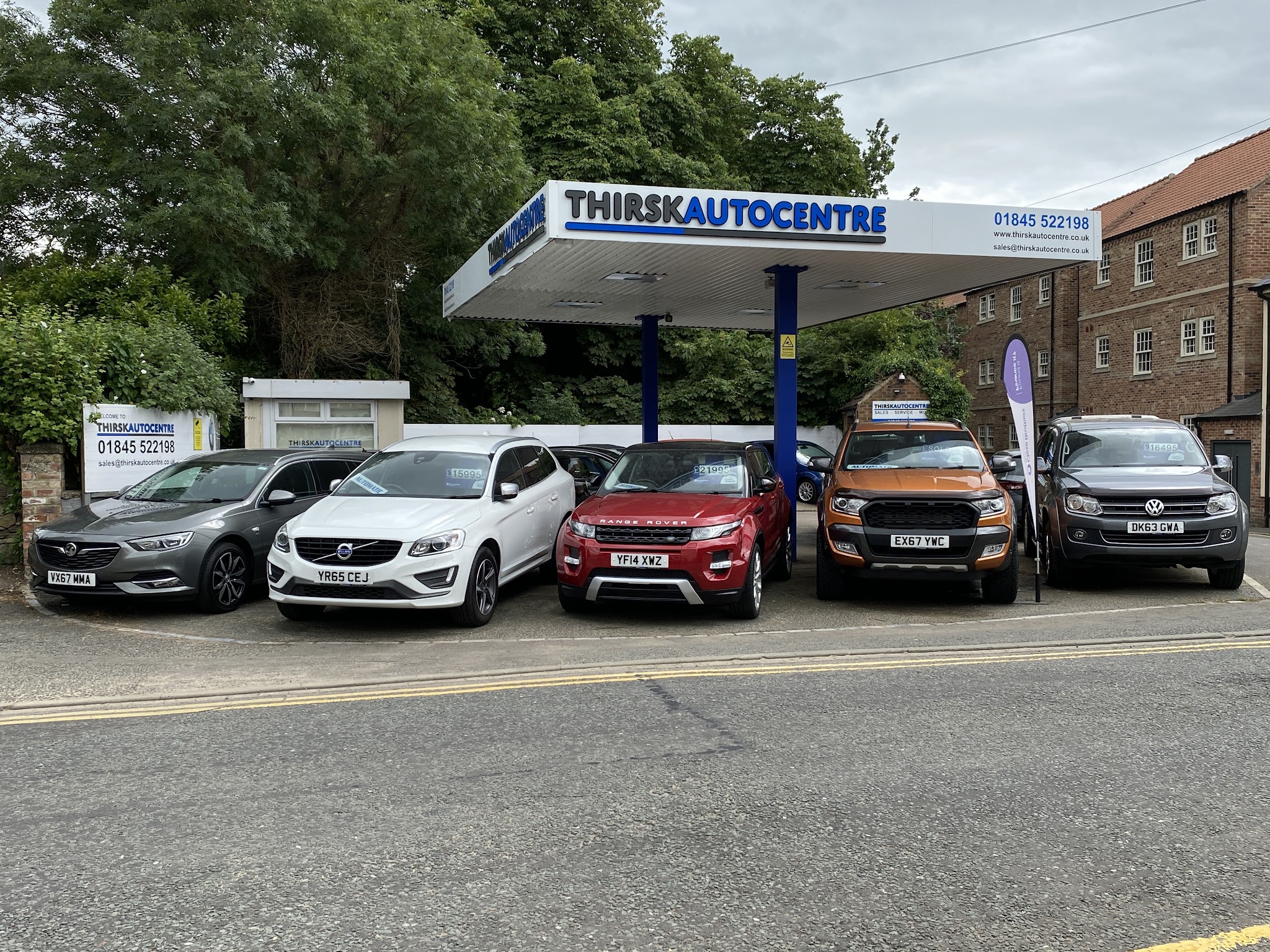 Thirsk Autocentre forecourt with the blue and grey canopy sign and used cars for sale