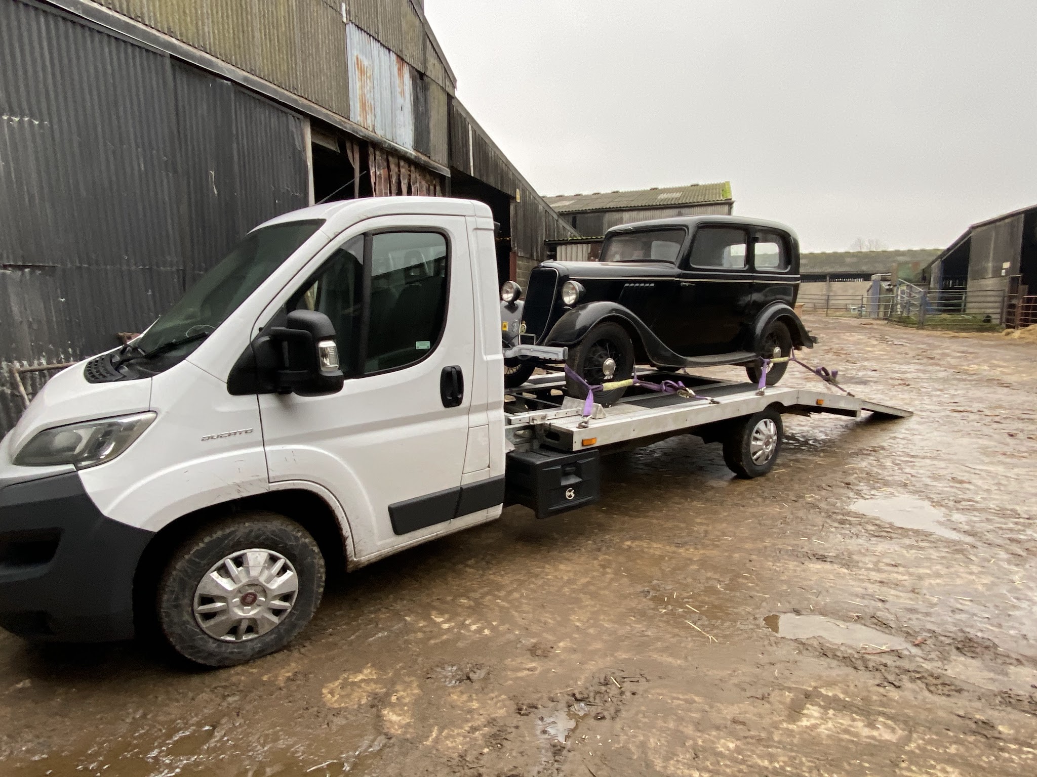 Thirsk Autocentre transporter carrying a vintage black car