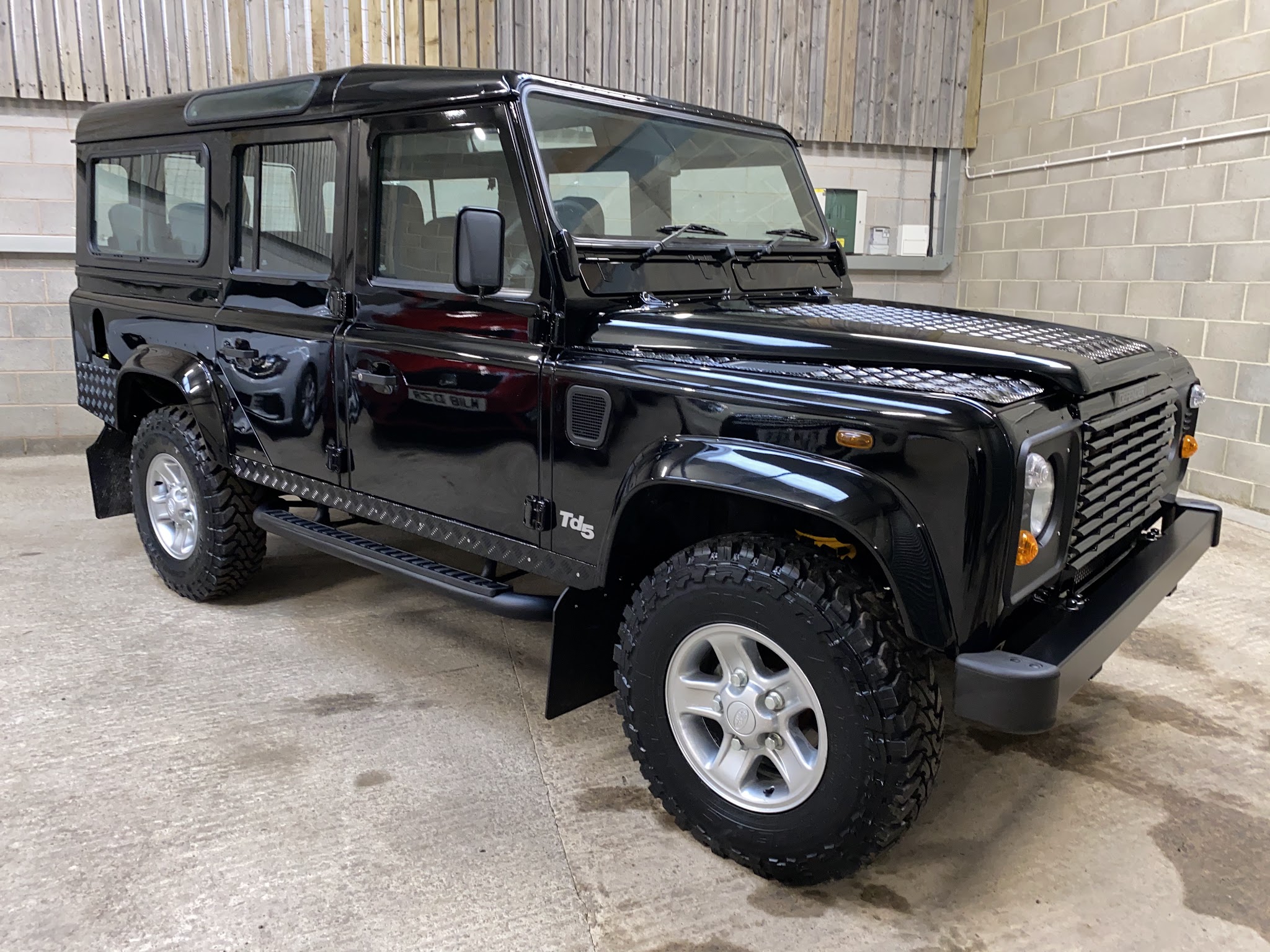 Black Land Rover Defender Td5 in the Thirsk Autocentre showroom bay